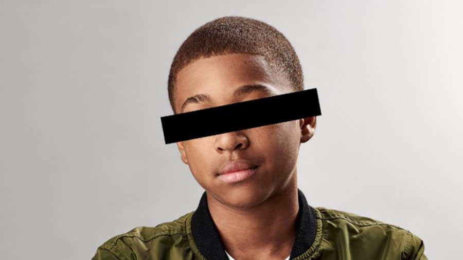 African American teenage boy with black bar over eyes