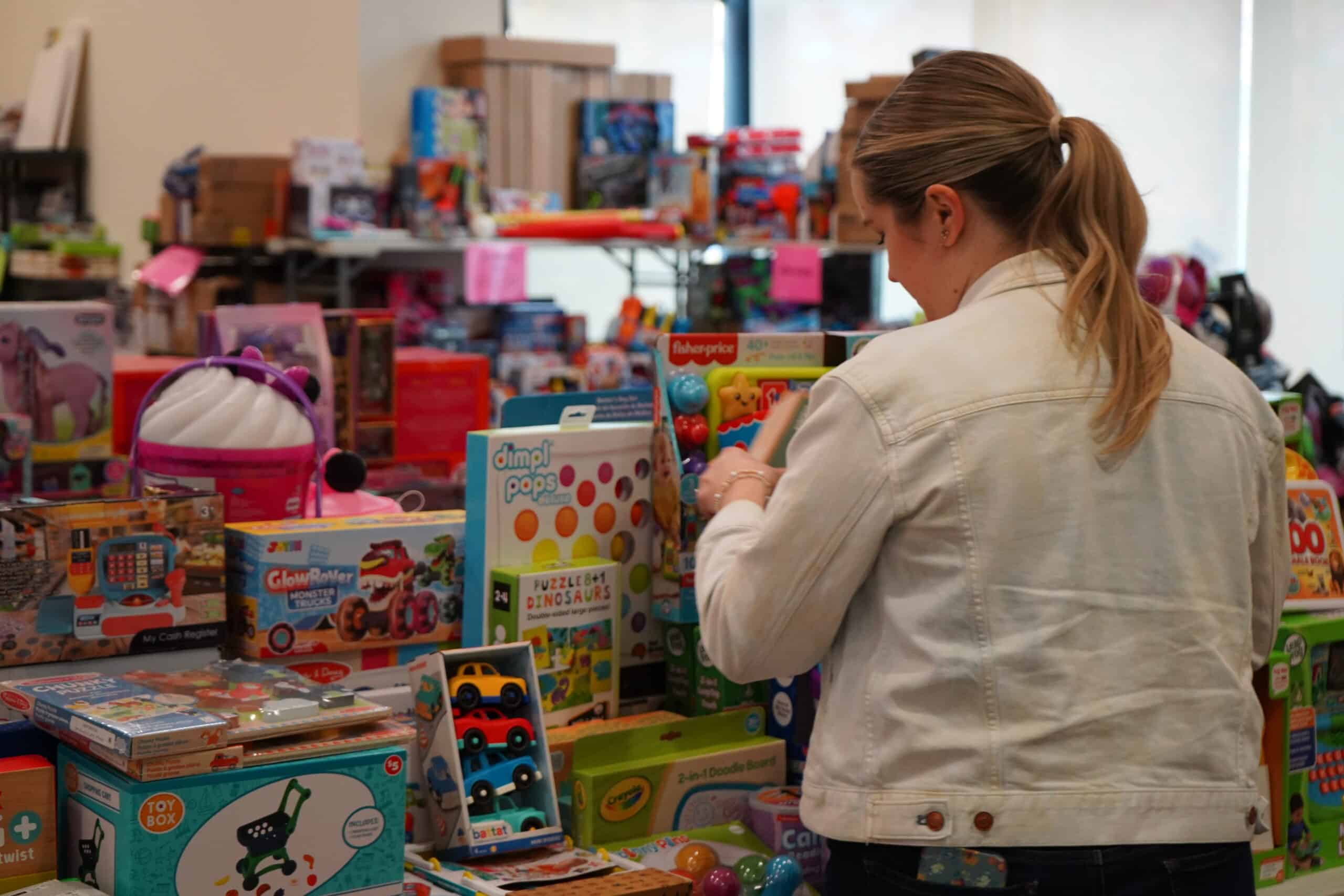Woman picking up toys and games for kids